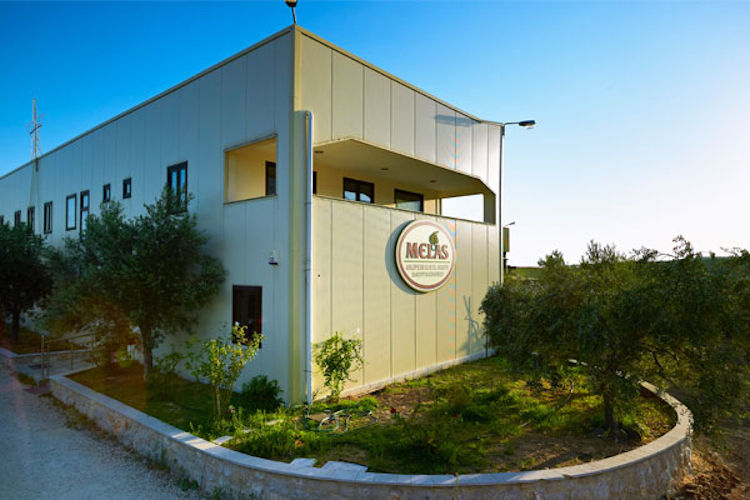 corner of Melas Epidauros industrial building outside surrounded by trees and green bunches